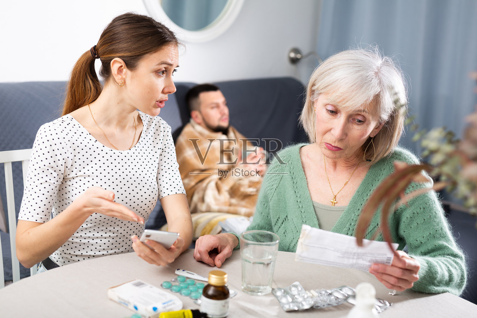 妇女为患病的成年男子挑选药品照片摄影图片