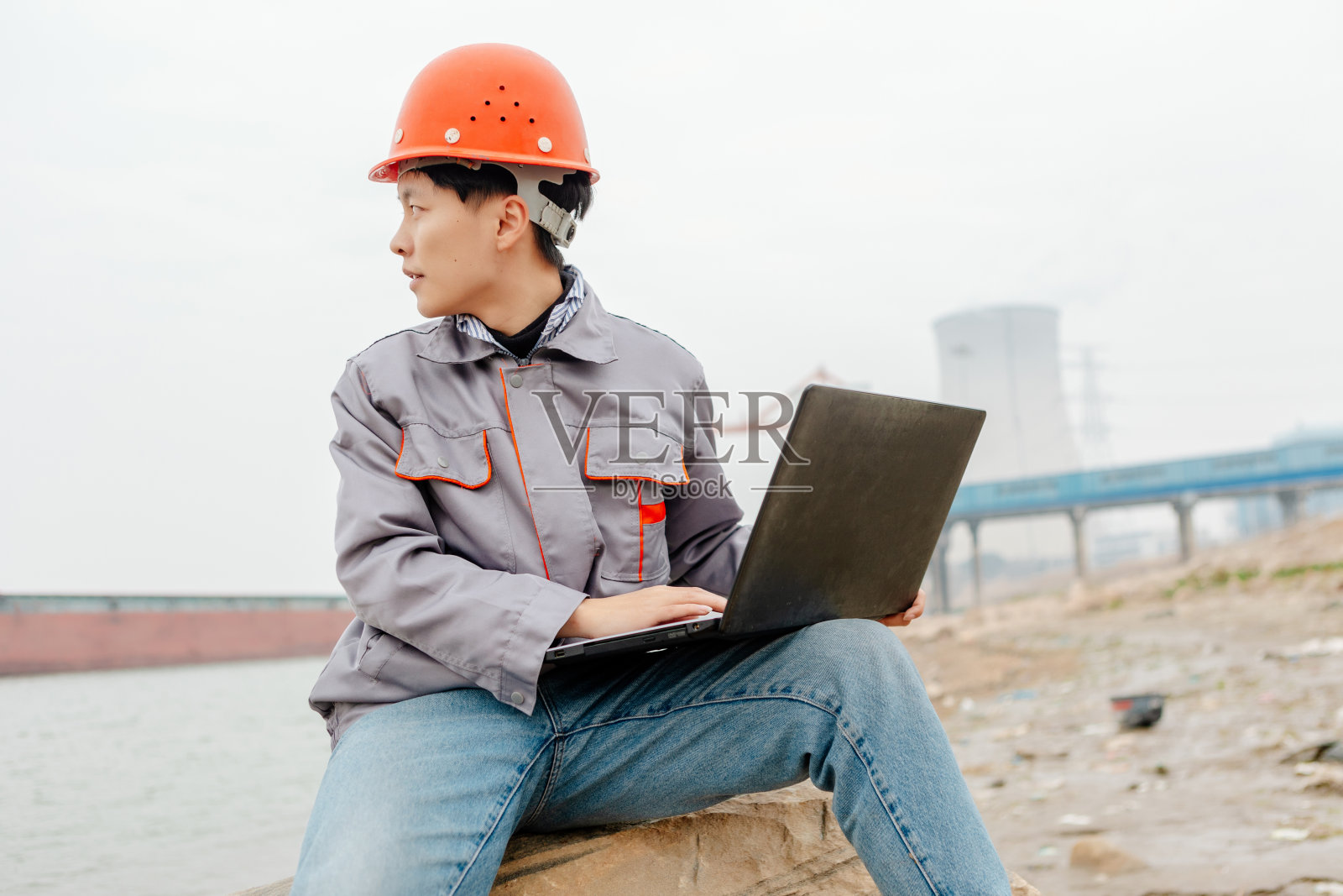 一名男性工程师在码头使用笔记本电脑记录数据并指挥工作照片摄影图片