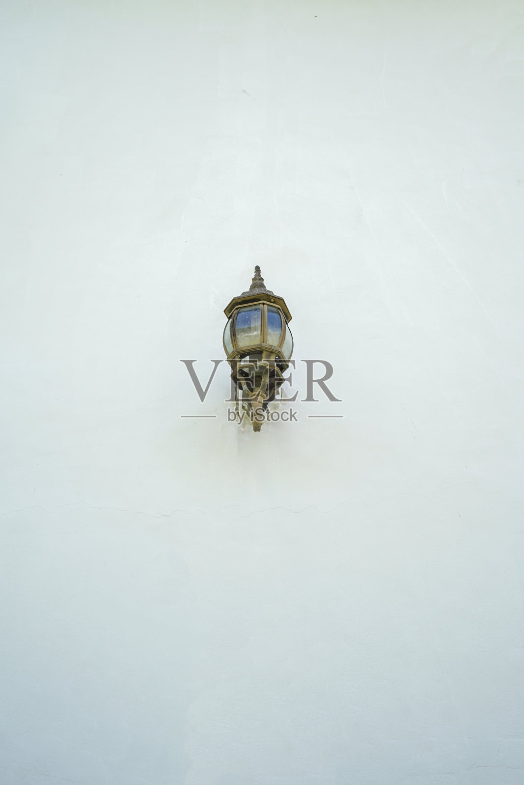 一盏路灯在白色建筑墙上的垂直镜头照片摄影图片