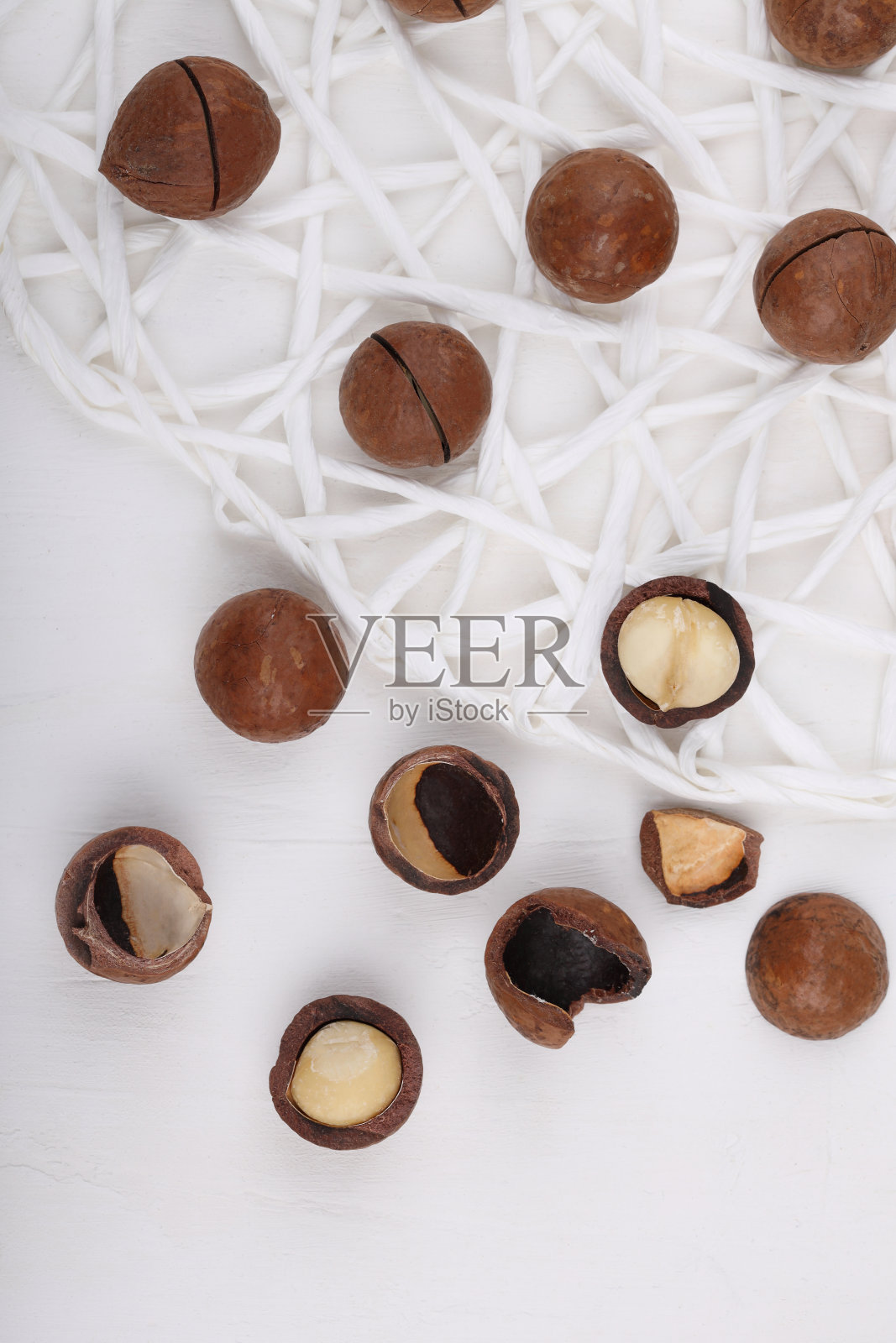 白色石头、石板或混凝土背景上的澳洲坚果特写,超级食物和健康营养的概念,以复古色调从上方或从上方观看的图片照片摄影图片