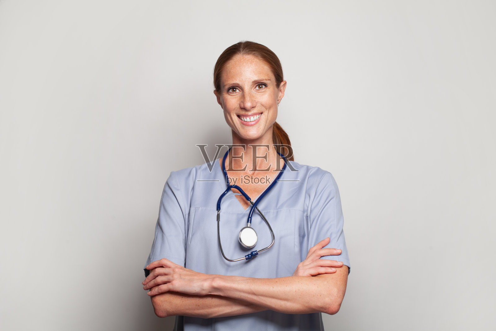 灰色背景上微笑的快乐医生照片摄影图片