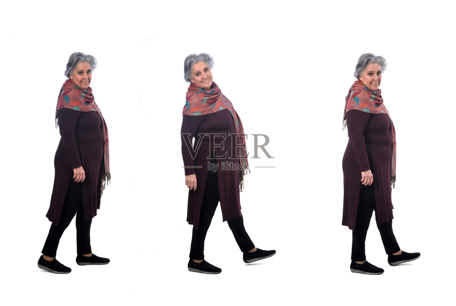 一组相同的高级妇女走着,看着白色背景的相机照片摄影图片