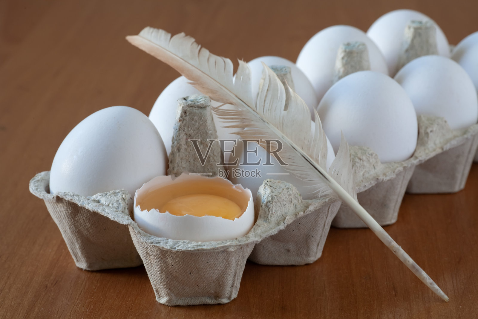 桌上的盘子里有鸡蛋。一个鸡蛋破了。照片摄影图片