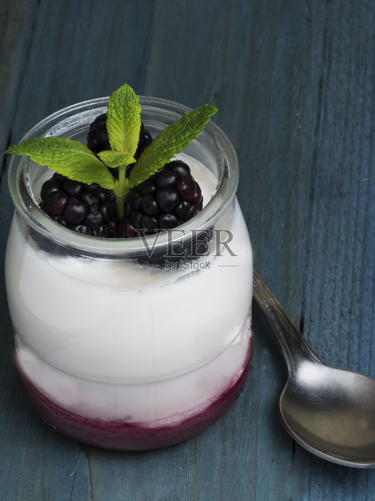 酸奶特写,黑莓和薄荷放在碗里,旁边有一个勺子照片摄影图片