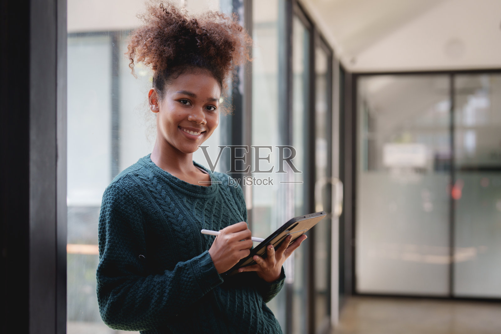年轻的黑卷发美国非洲妇女使用数字平板电脑照片摄影图片