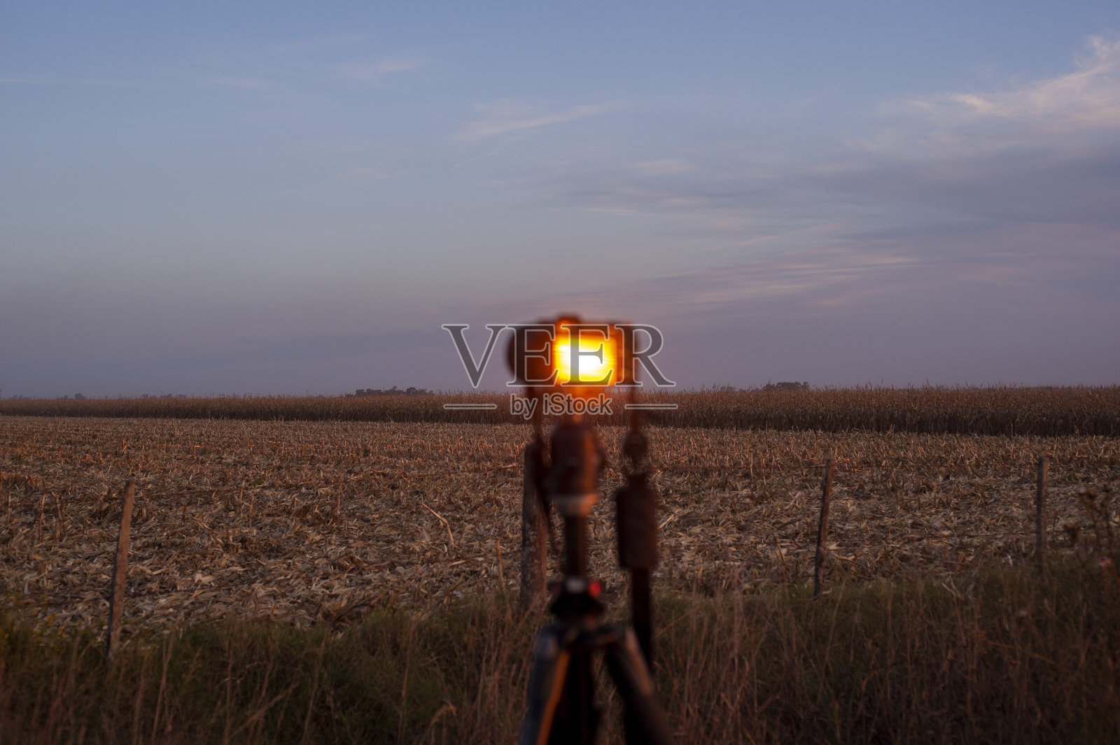 三脚架上的相机捕捉到了农场的日落照片摄影图片