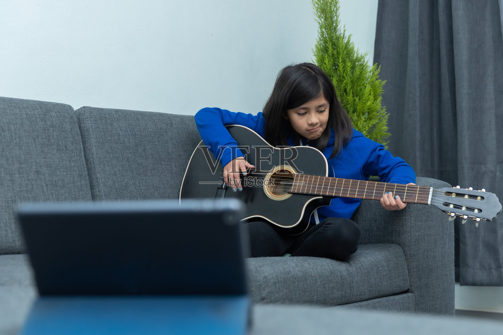 一个墨西哥女孩在学弹吉他照片摄影图片