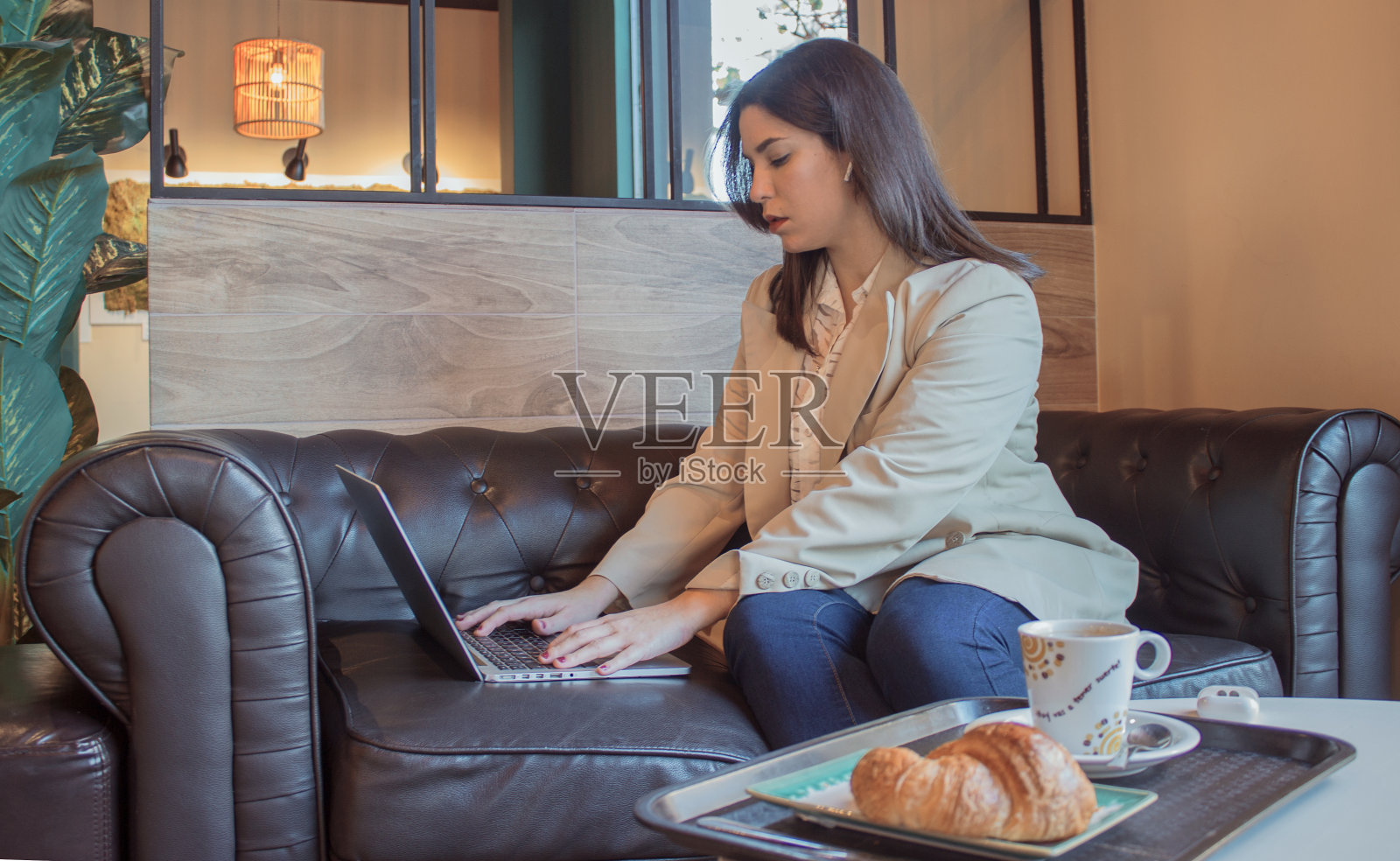 休息时,一位年轻漂亮的女商人在咖啡馆里专注于笔记本电脑照片摄影图片