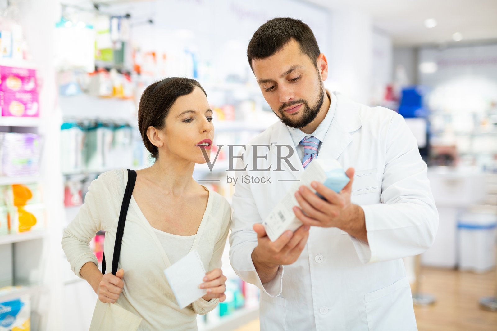 女性购买者在药店向药剂师咨询该买哪种乳液或药膏照片摄影图片