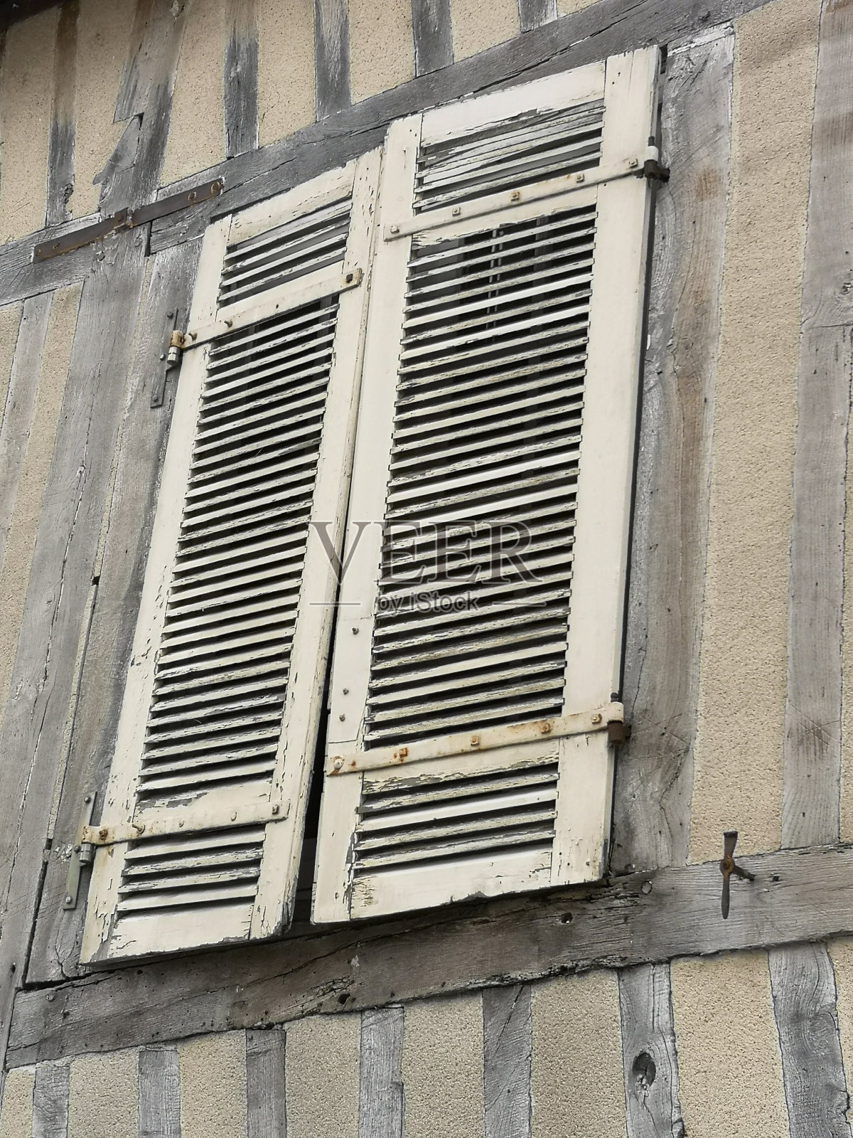 Old weathered shutters on a house in Normandië, France.照片摄影图片