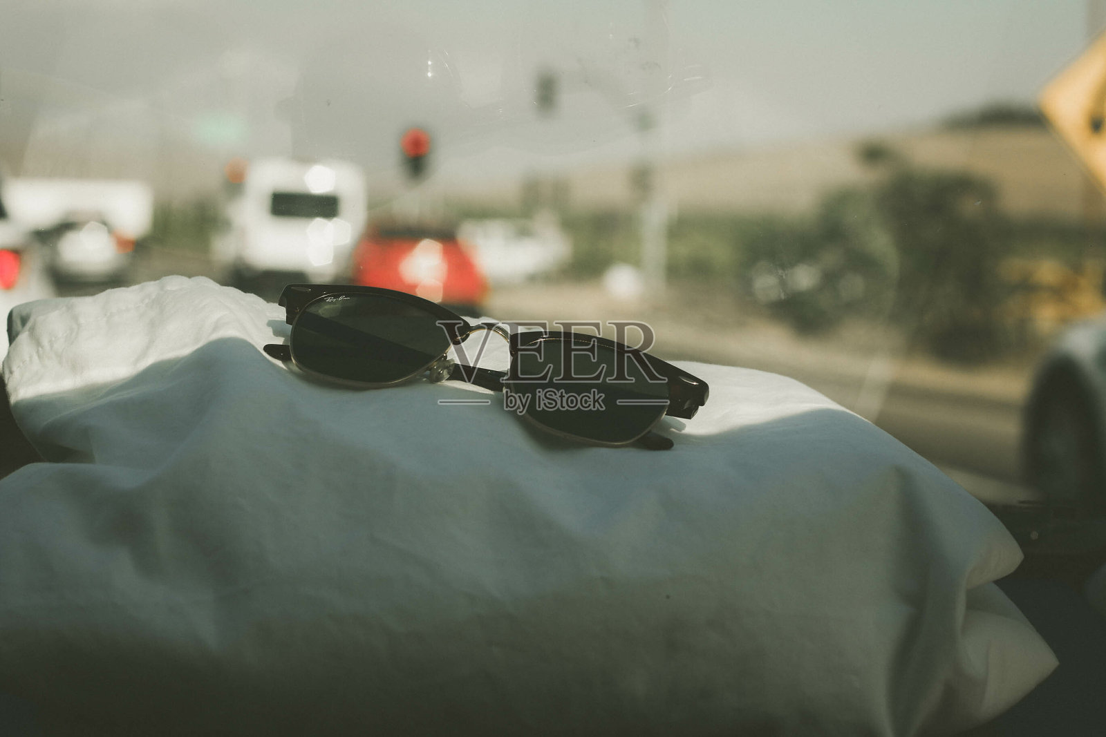 在阳光下,一副太阳镜在汽车的枕头上特写照片摄影图片