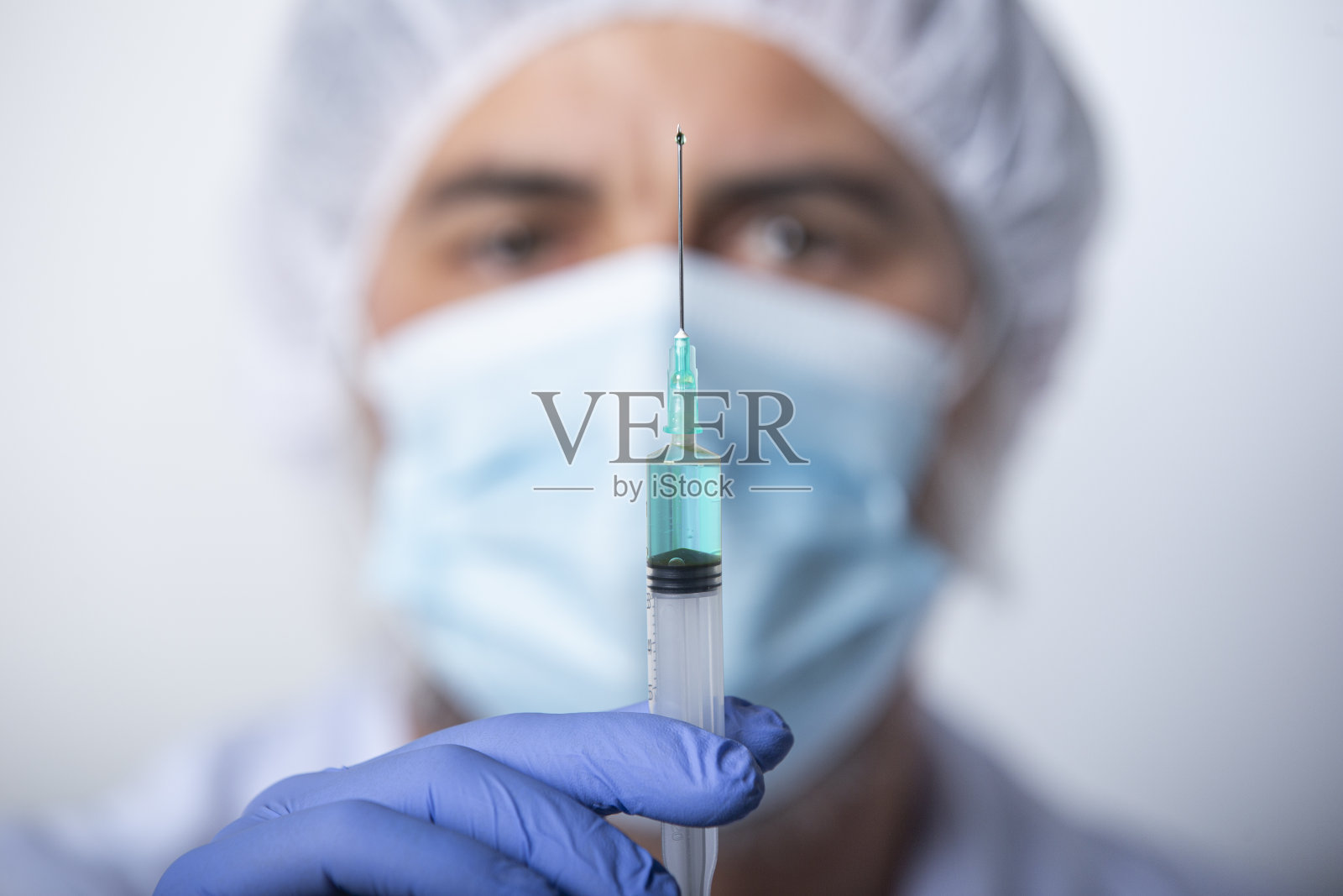 医生兼科学家,戴着蓝色手套,拿着疫苗注射器照片摄影图片