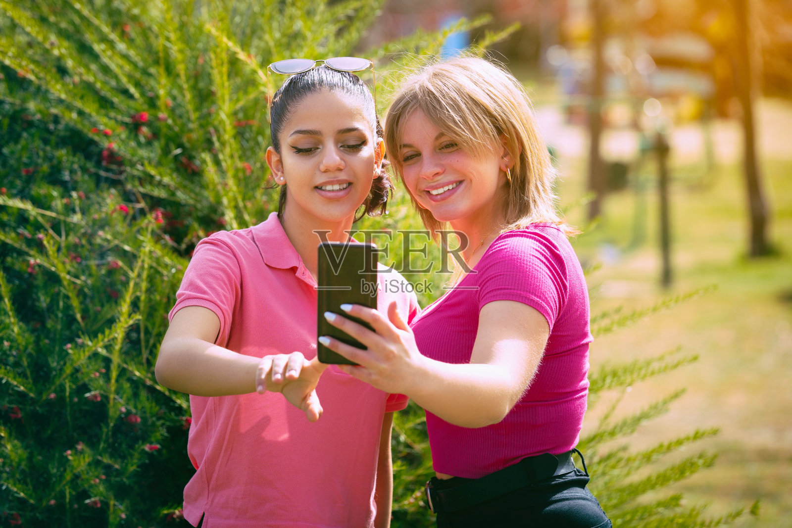 两个西班牙女人在一个阳光明媚的日子里在公园里自拍照片摄影图片