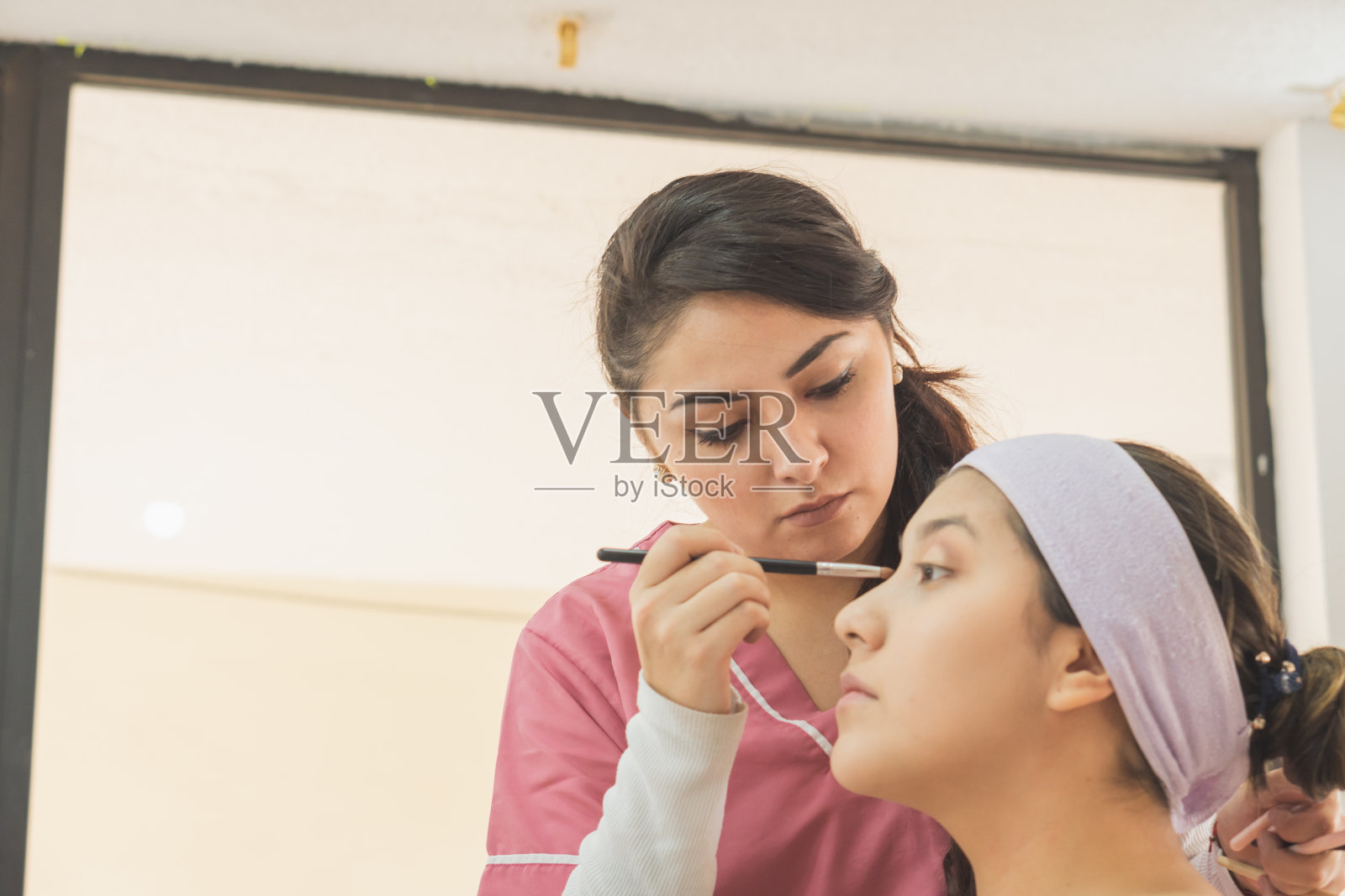 一名年轻女子正准备为一个特殊的活动化妆。照片摄影图片