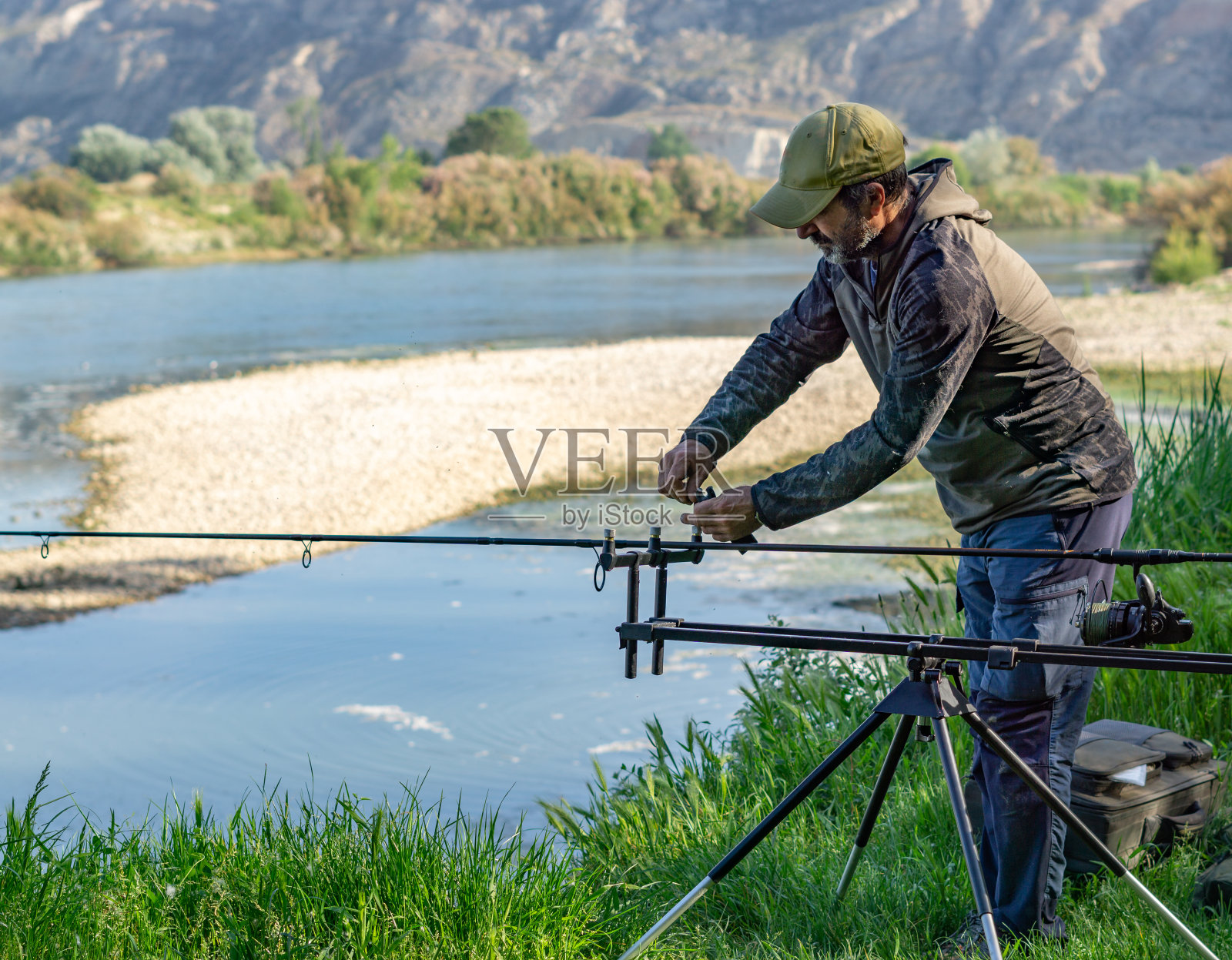 特写镜头的白人男子胡须鲤鱼钓鱼在河里照片摄影图片