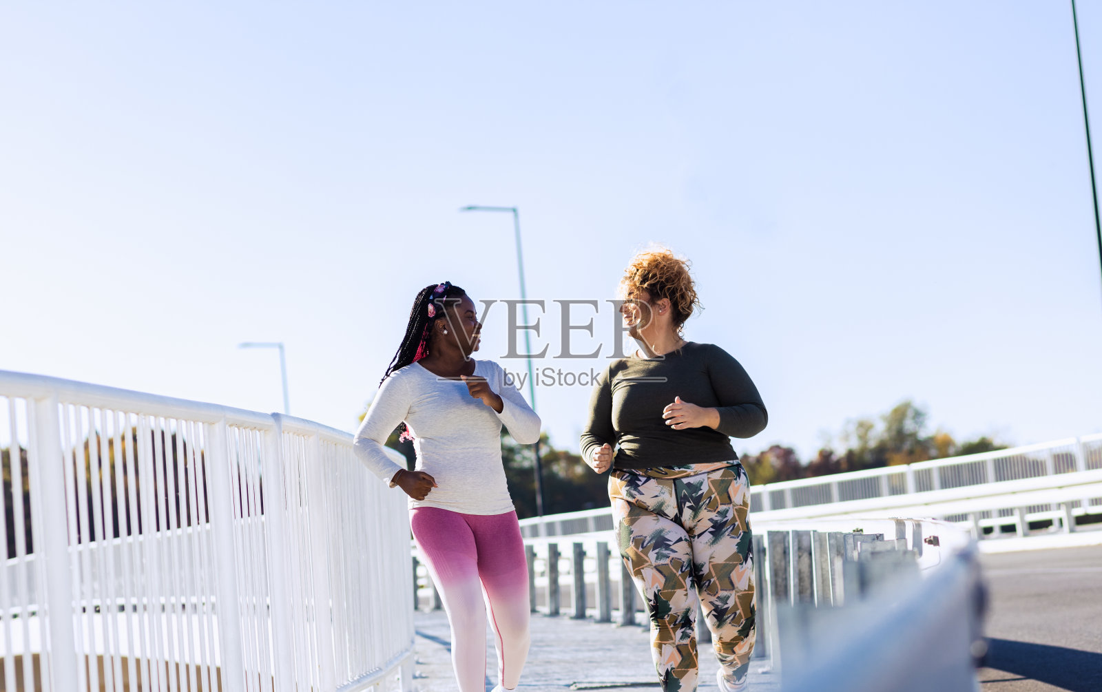 两个年轻的大码女人一起慢跑。照片摄影图片