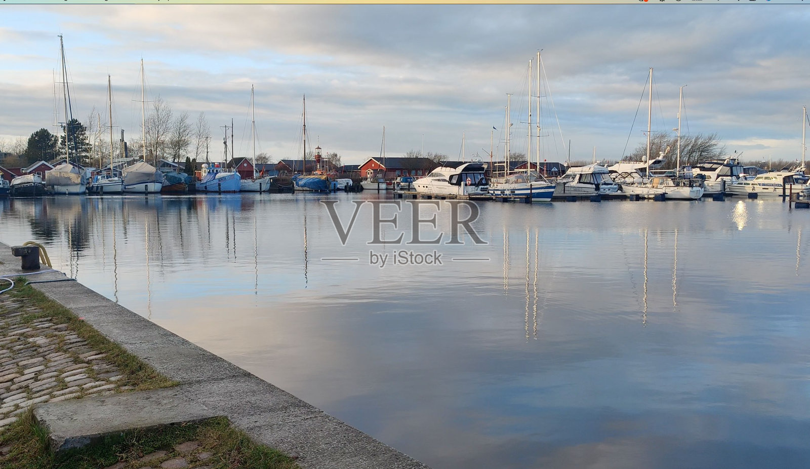 在多云的天空下,美丽的船只进入码头公园照片摄影图片