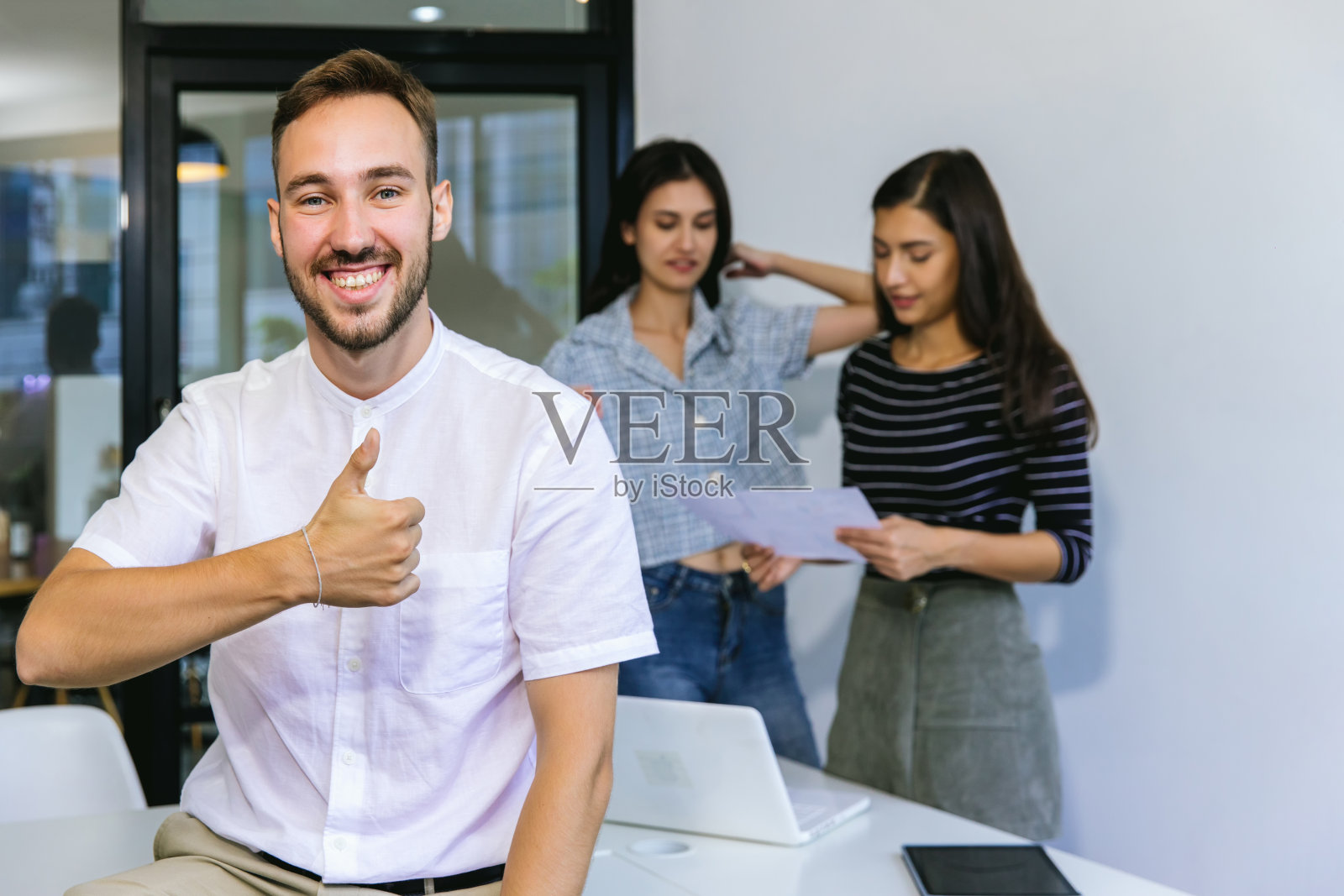 英俊的商人在明亮的现代办公室的笔记本电脑上工作照片摄影图片