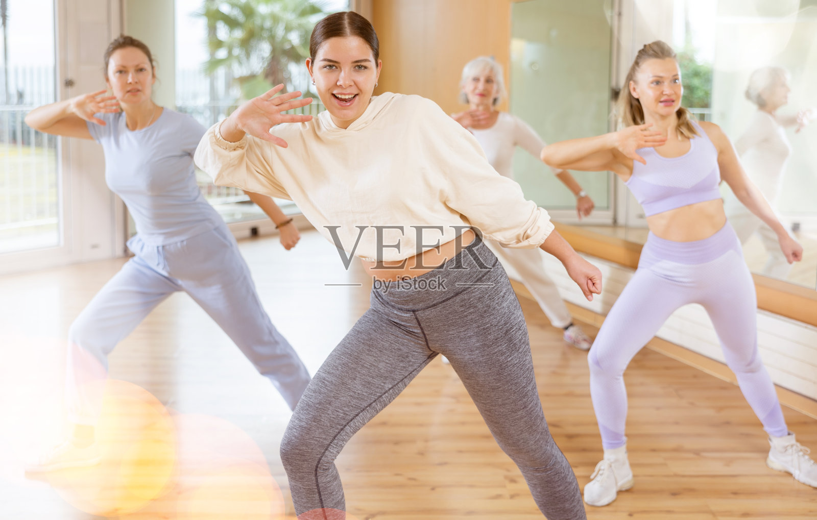 不同年龄的兴奋积极的女性在学校为成人表演现代舞蹈练习照片摄影图片