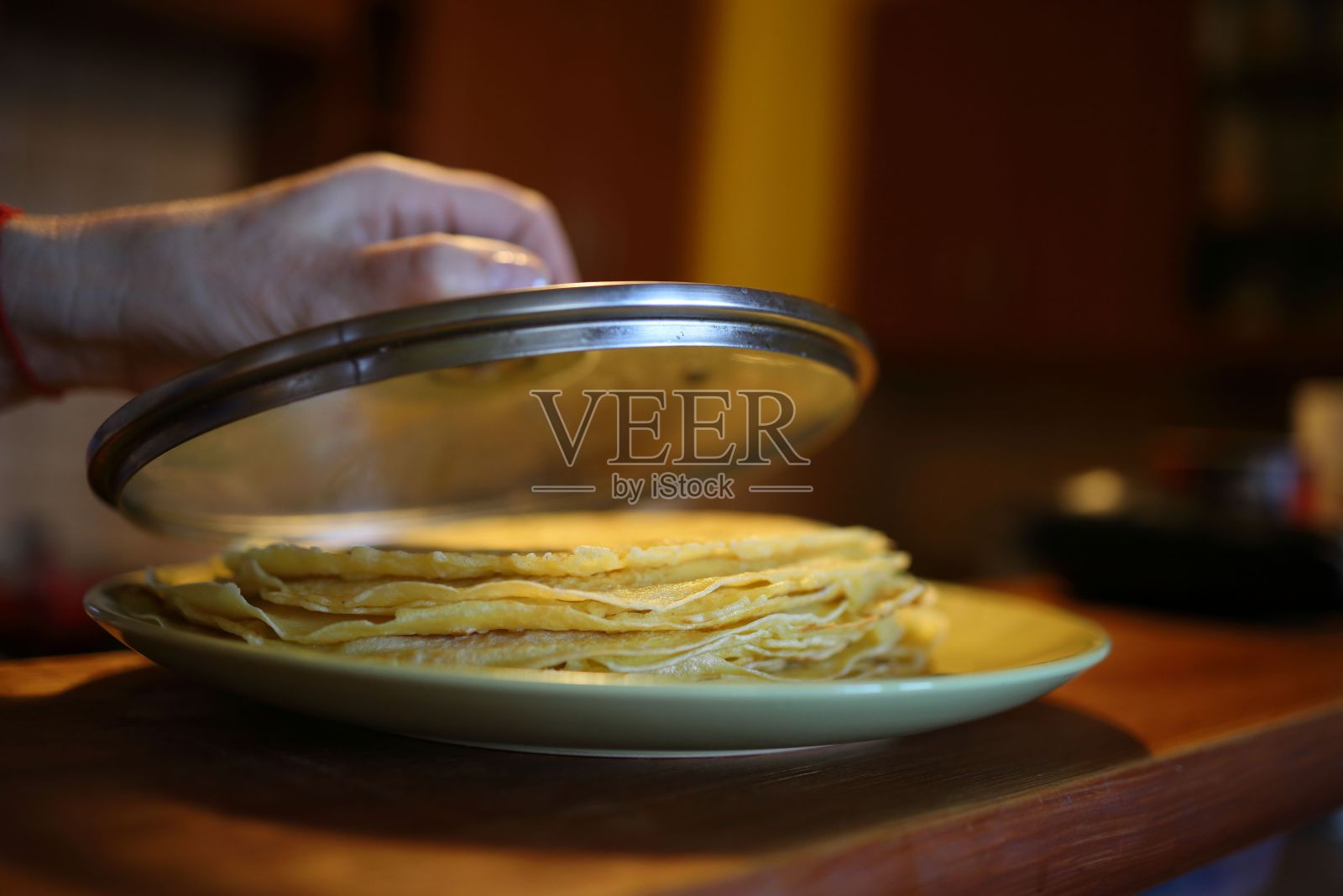 一个人在盘子里盖一叠煎饼的选择性聚焦镜头照片摄影图片