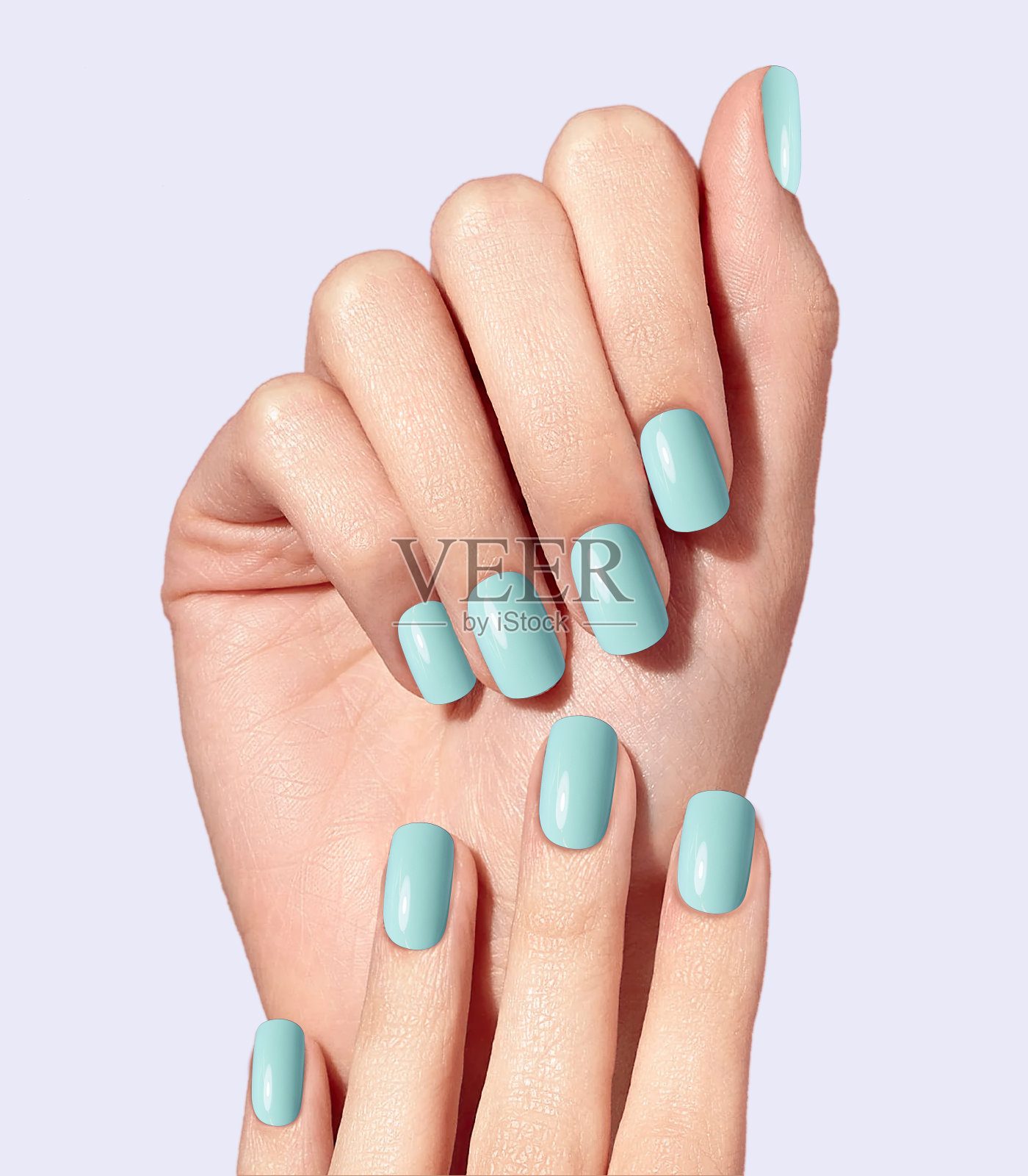 白色背景上的美女之手。双手细腻,指甲修剪自然,皮肤干净,指甲淡蓝色。照片摄影图片
