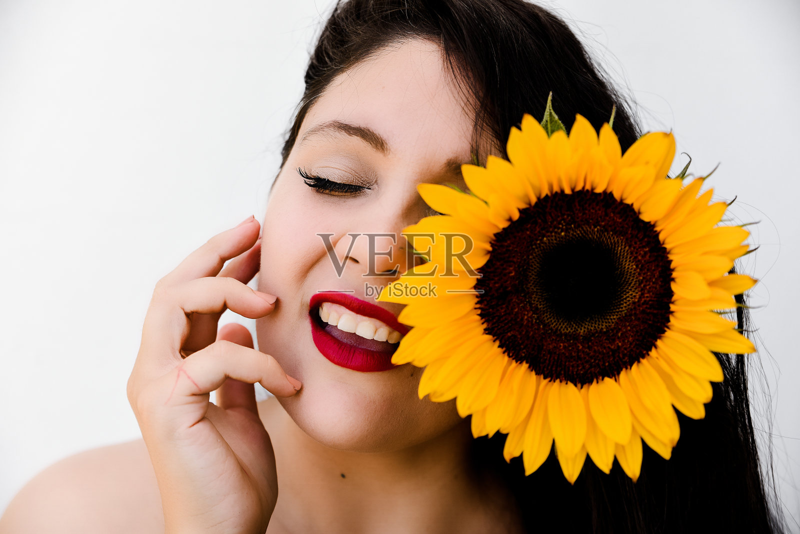 红唇女孩,脸上涂着向日葵。欢迎春天照片摄影图片