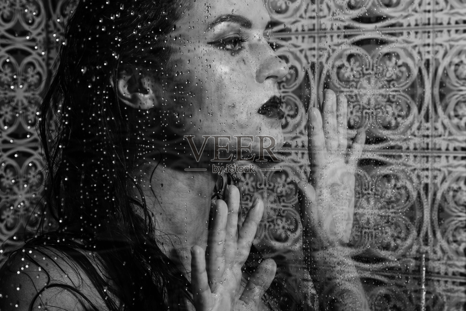 通过湿玻璃捕捉的美丽而感性的女人的肖像照片摄影图片