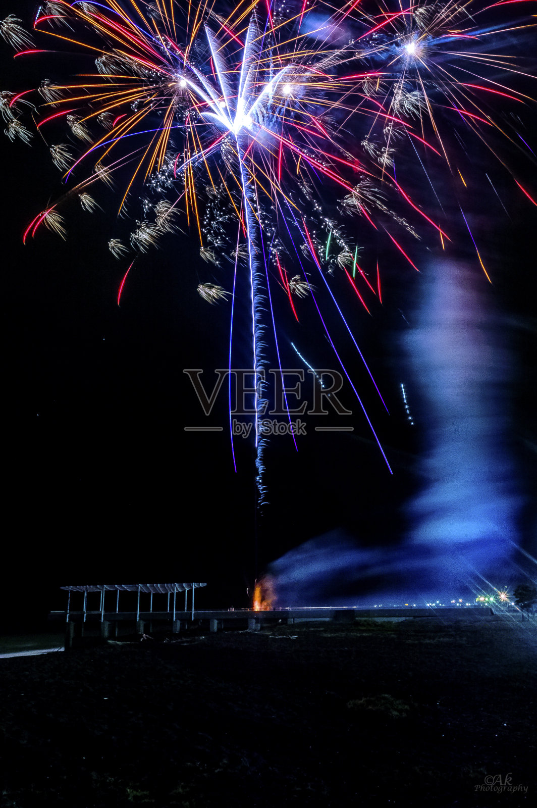 垂直拍摄的彩色烟花在蓝天中爆炸照片摄影图片