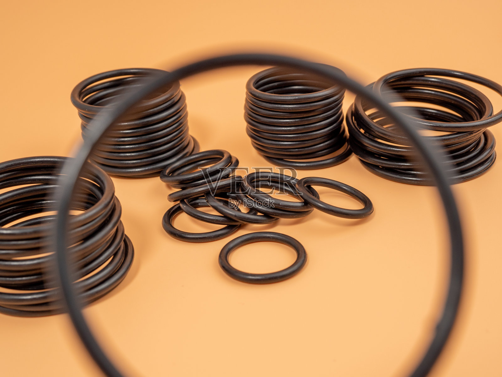 液压和气动o形环在不同大小的黑色在橙色背景。管道用橡胶垫圈。照片摄影图片