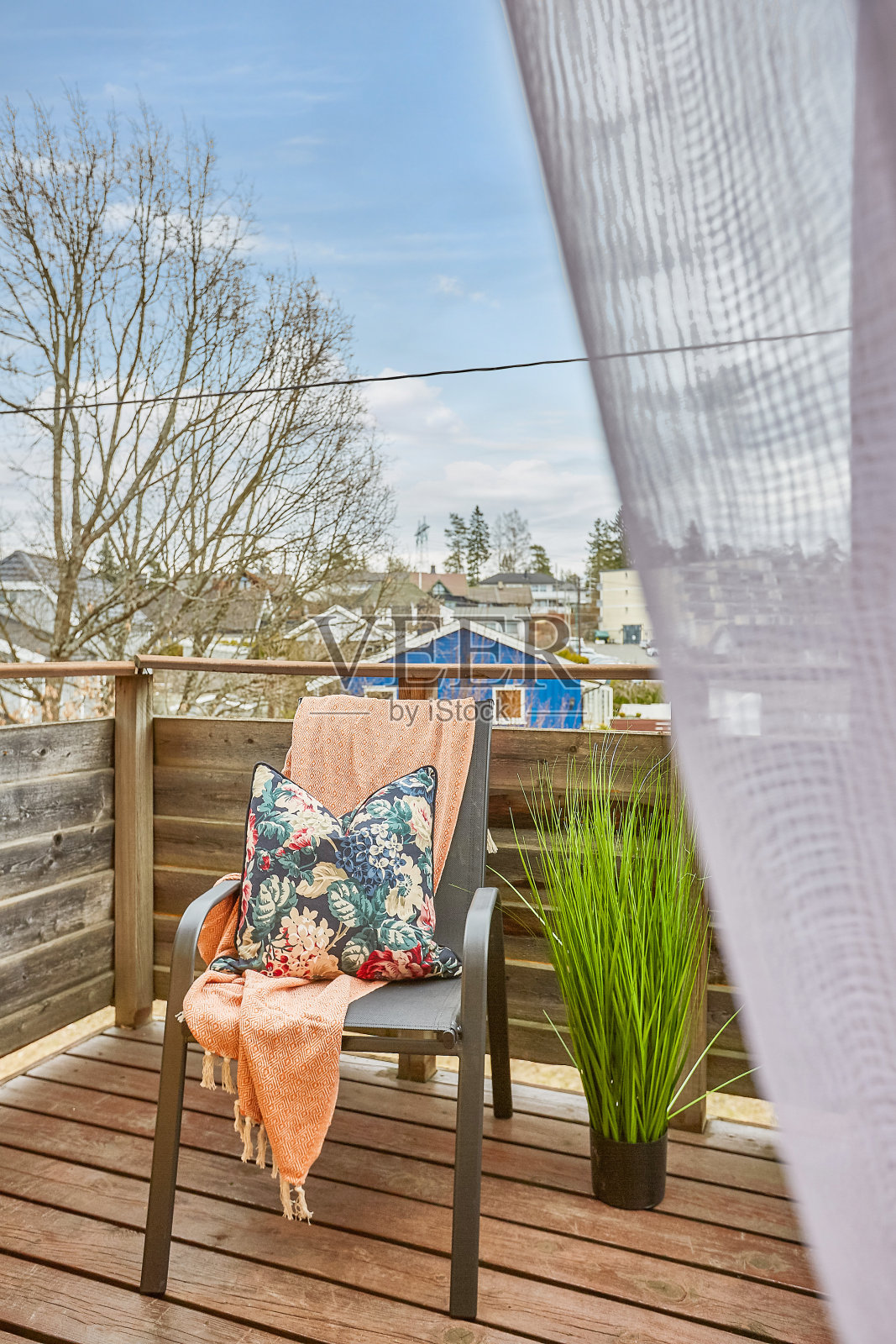 垂直拍摄阳台上的一把椅子,上面有一个枕头和一块布料照片摄影图片