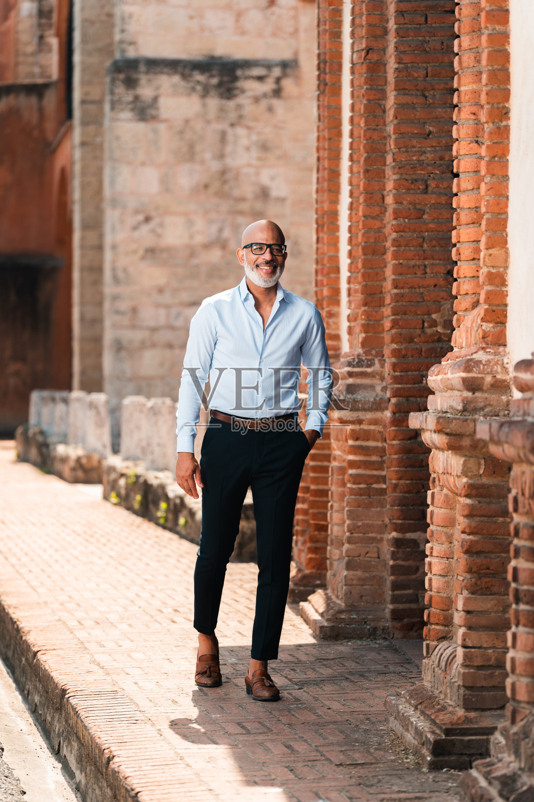 一个英俊时尚的西班牙男性在街上摆姿势的垂直镜头照片摄影图片