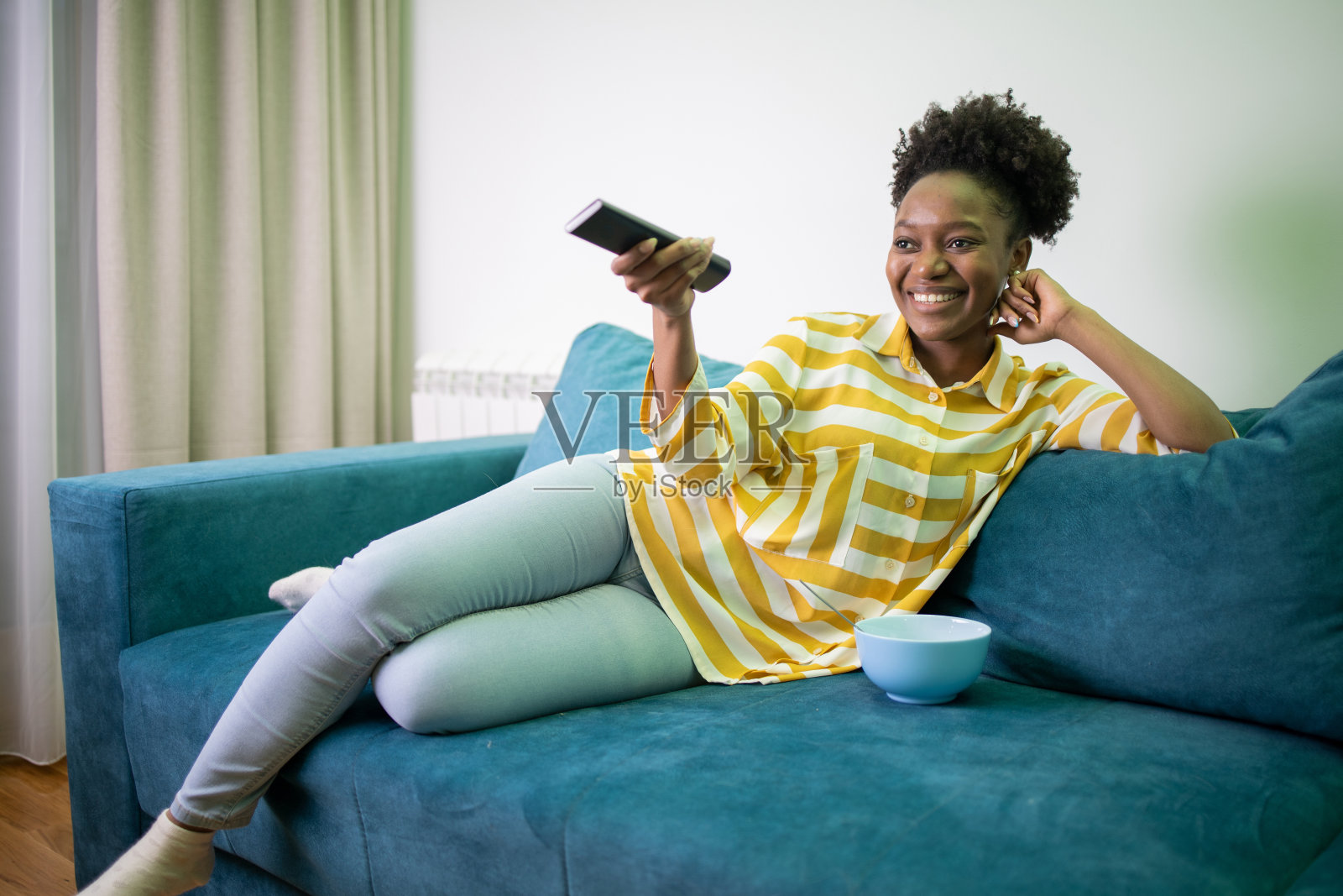 女人在家里享受她最喜欢的电视节目照片摄影图片