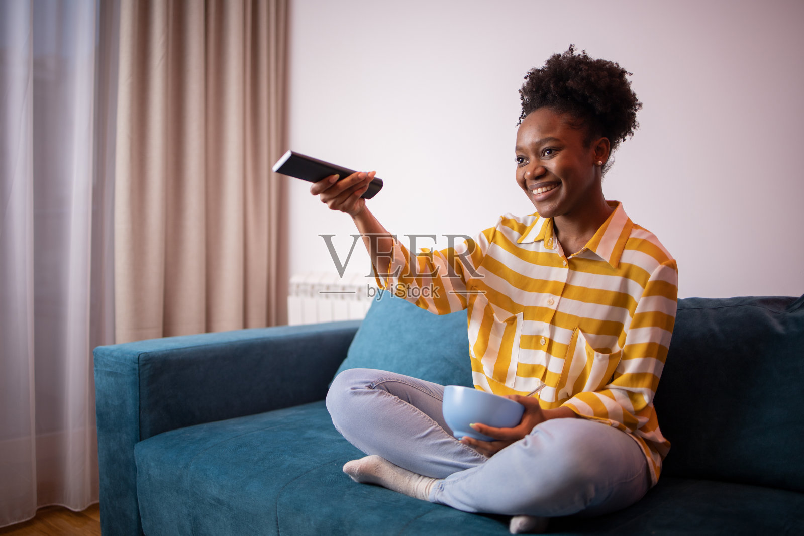 女人在家里享受她最喜欢的电视节目照片摄影图片