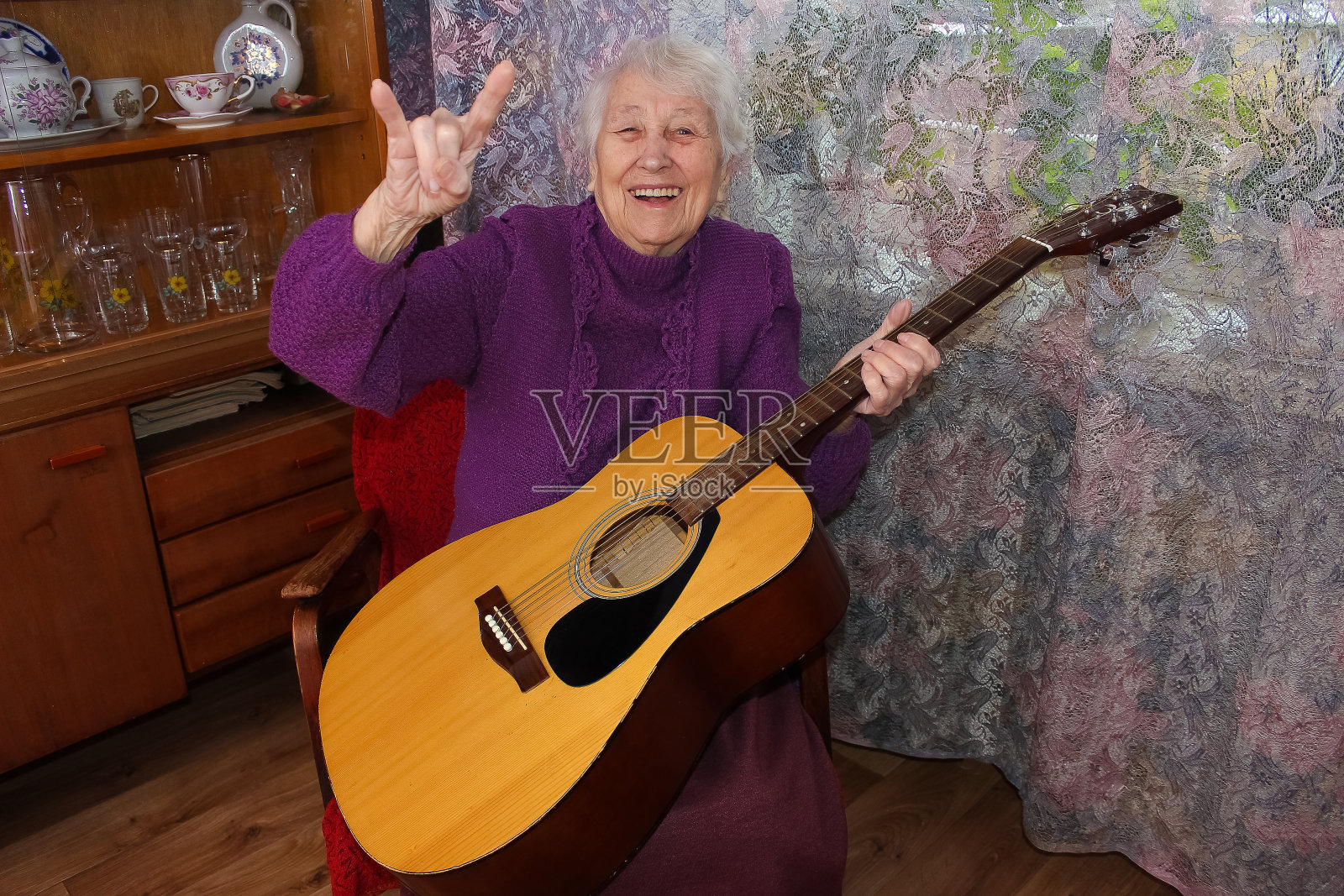 老年妇女在家里弹吉他照片摄影图片