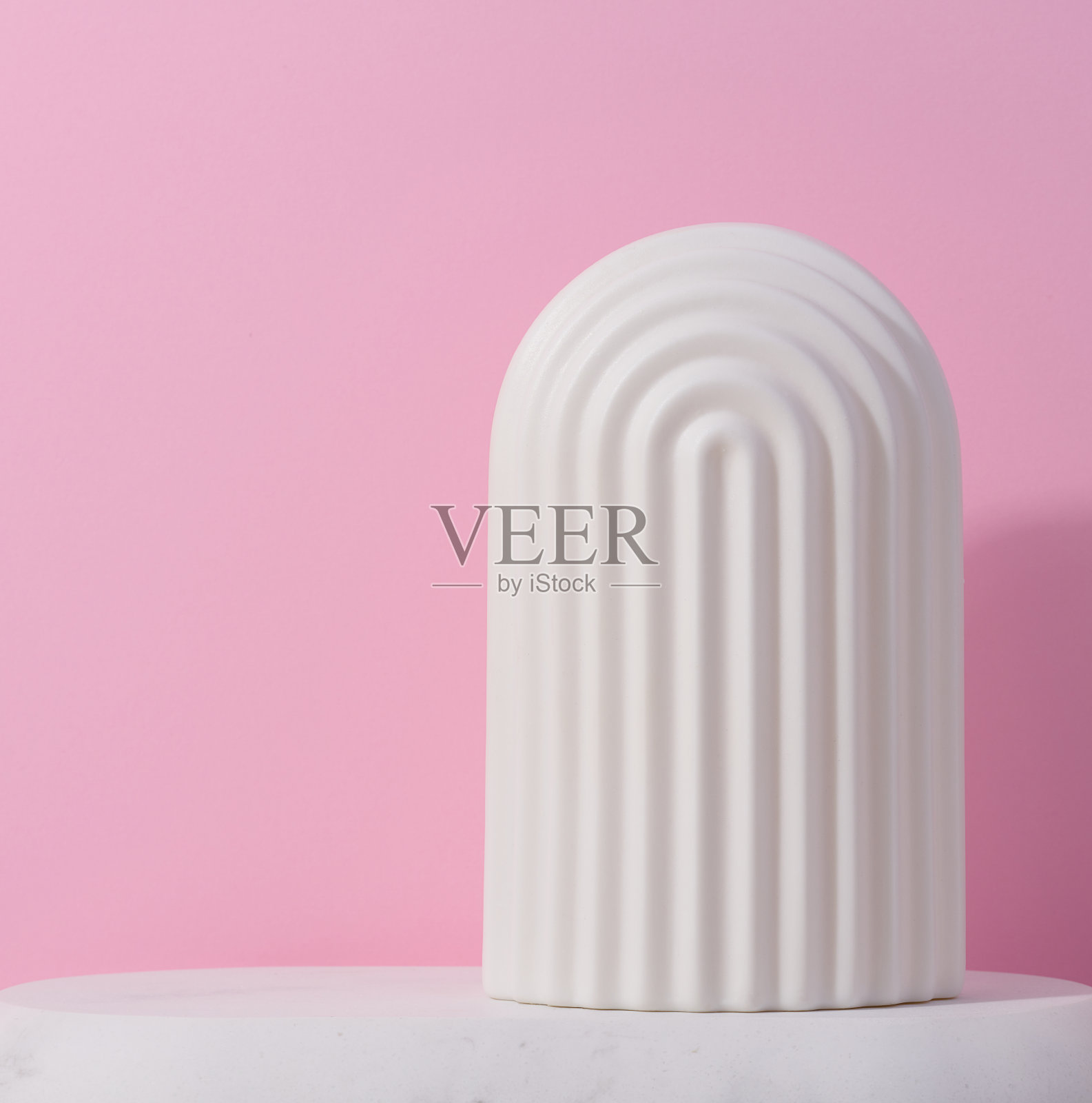 白色陶瓷装饰拱门上的粉红色背景,背景展示化妆品,产品,广告和促销照片摄影图片