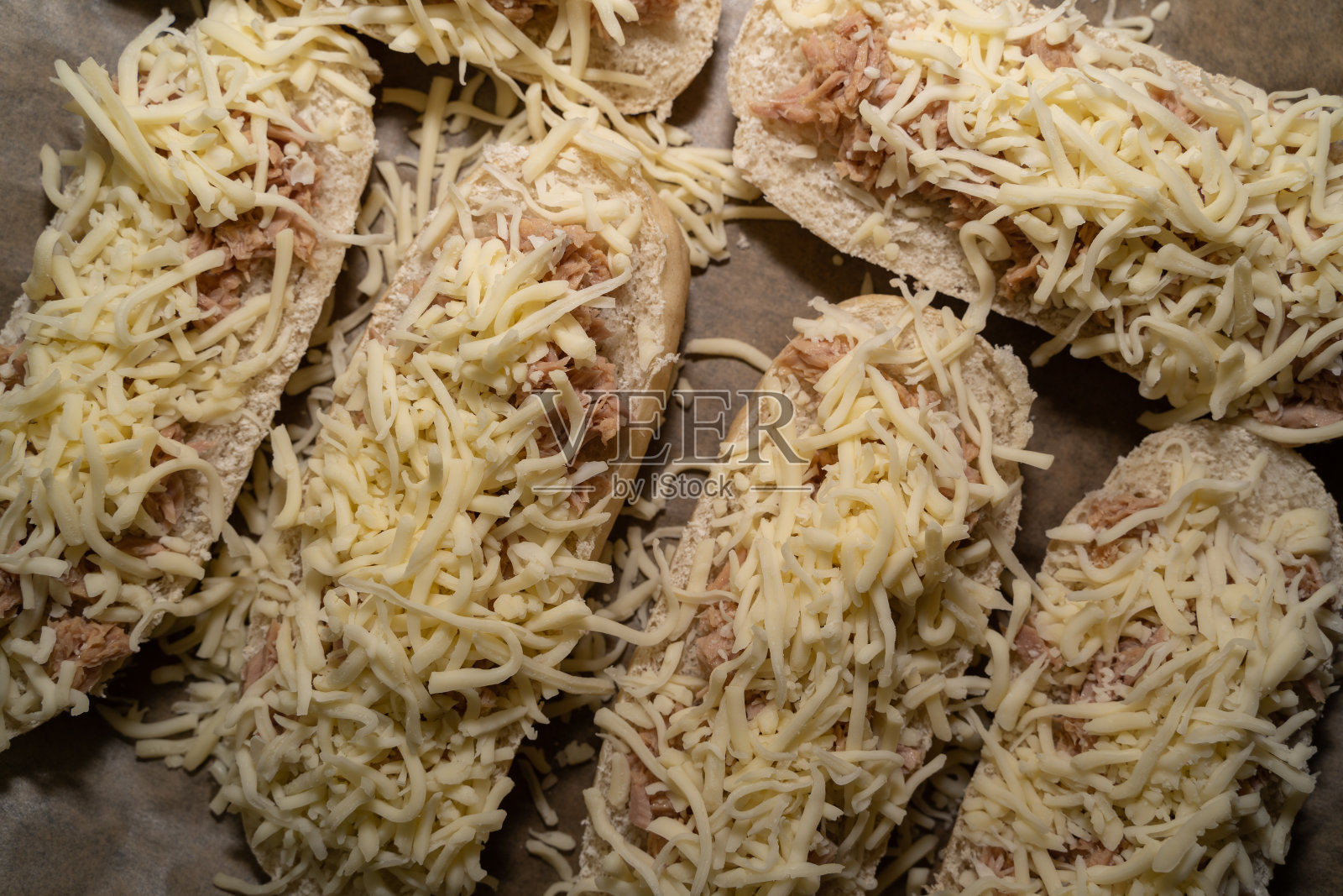 顶部视图的未烤法棍面包金枪鱼和奶酪在烤盘上照片摄影图片