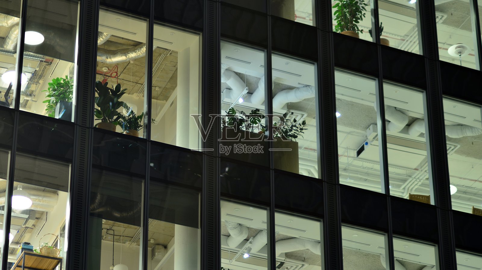 城市中现代化的办公大楼在夜晚。公司建筑的照明办公室视图。照片摄影图片