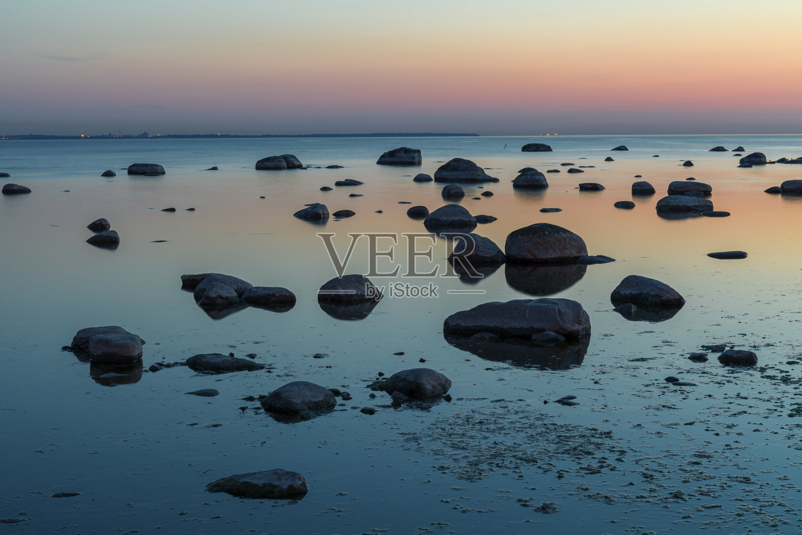 波罗的海岸边的黄昏日落。多岩石的海岸。照片摄影图片