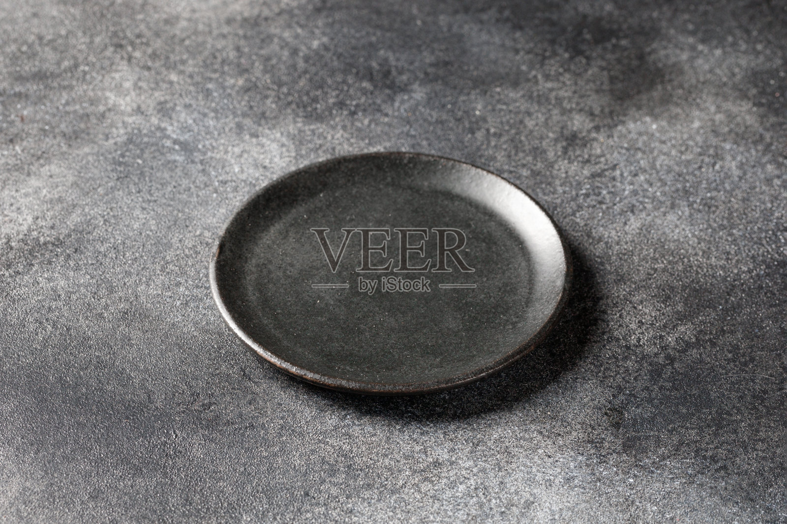 灰色桌子上空的深灰色盘子,背景。模拟,模板,显示。照片摄影图片