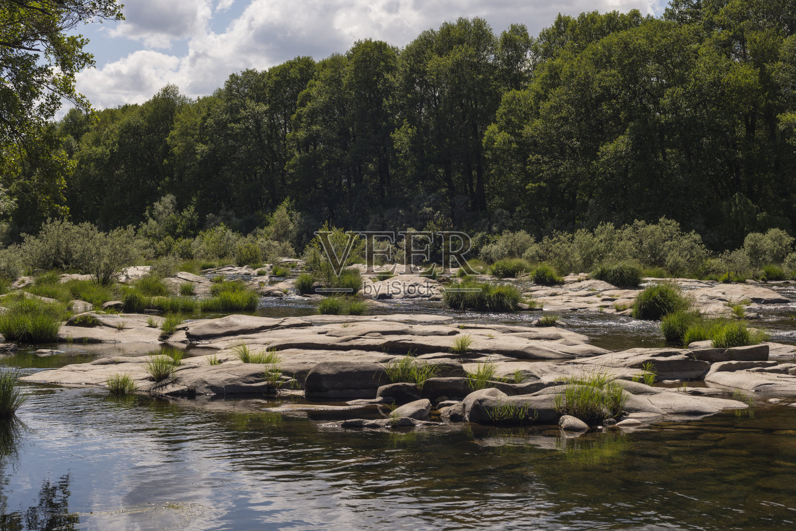 在西班牙的巴科阿维拉卡斯蒂亚拉曼查,河流流过巨大的石头和绿色的树木照片摄影图片