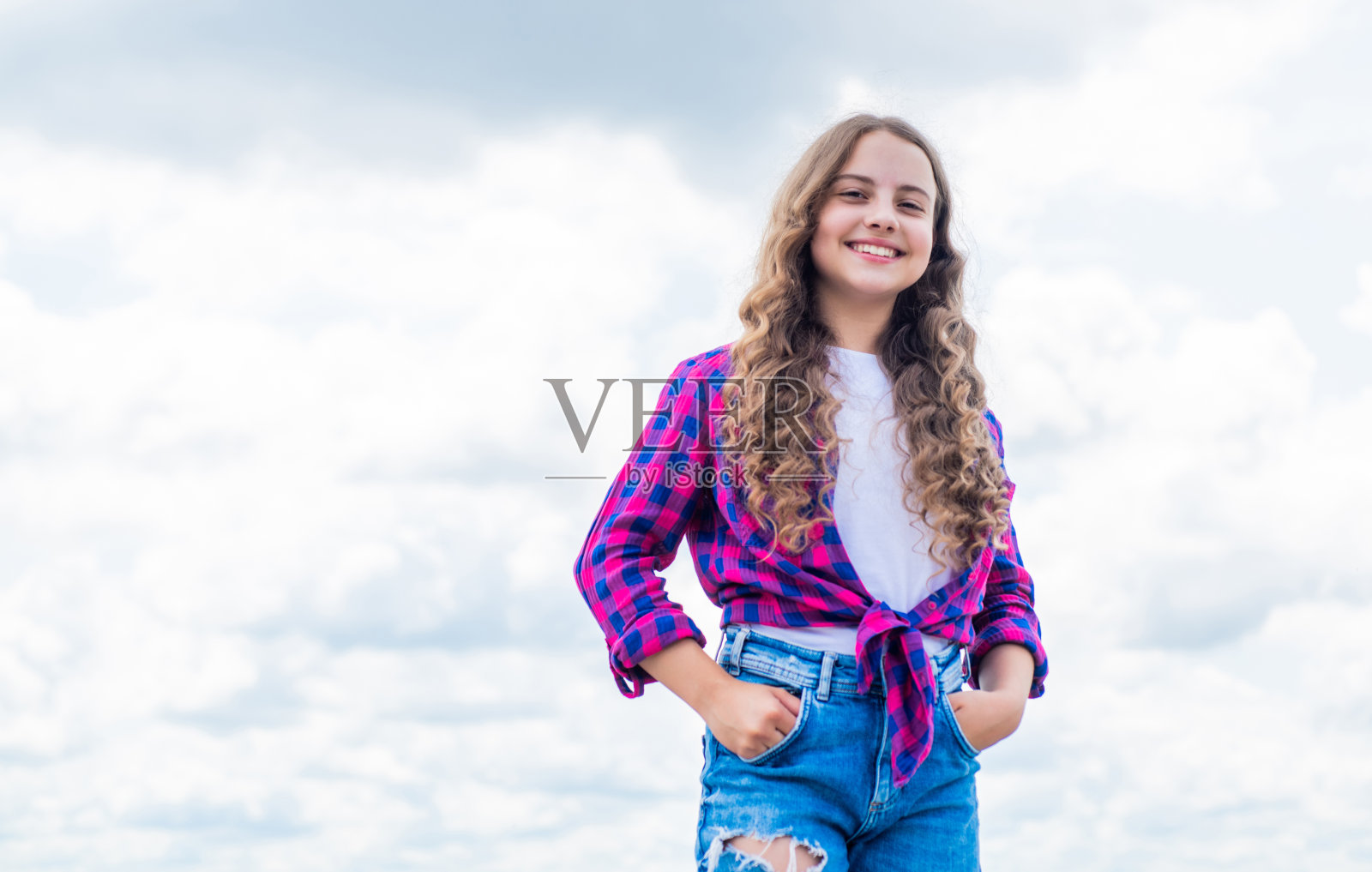 孩子在天空的背景上。暑假概念。童年的幸福。儿童节快乐。释放你的想象力。儿童美容与时尚。孩子穿着休闲风格。本空间照片摄影图片