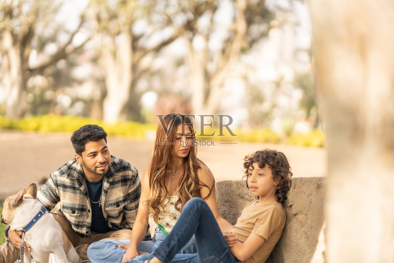 悠闲的家庭和一只狗躺在公园里照片摄影图片