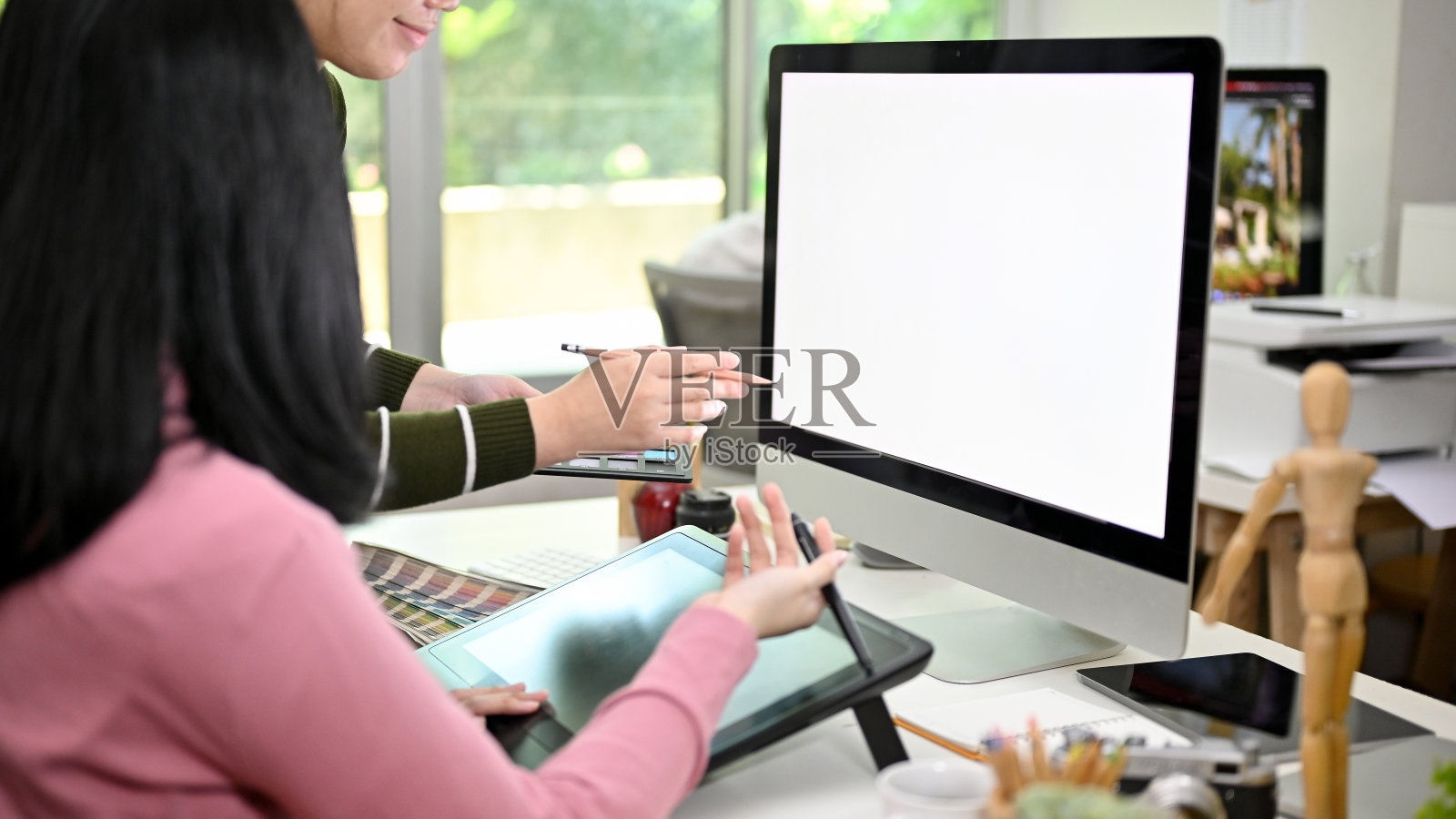 两位富有创意的亚洲女性平面设计师一起在工作室工作。计算机模型照片摄影图片