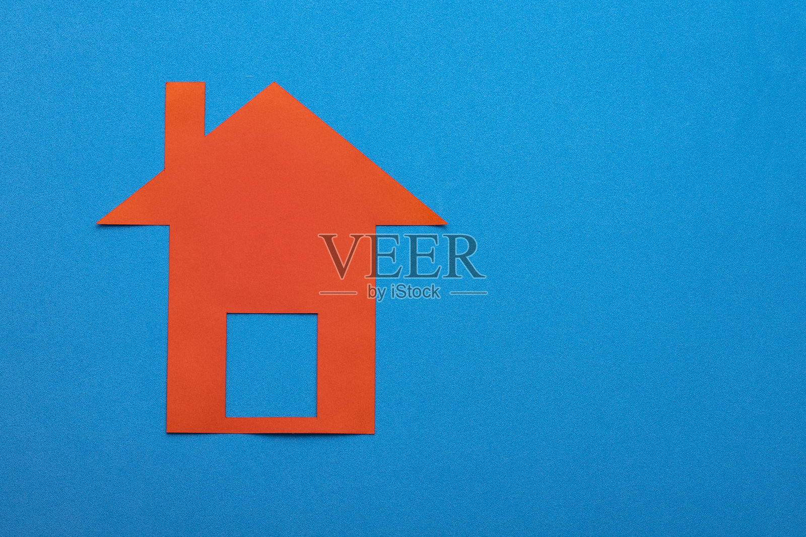 房屋买卖概念-蓝色背景上的红纸房子照片摄影图片