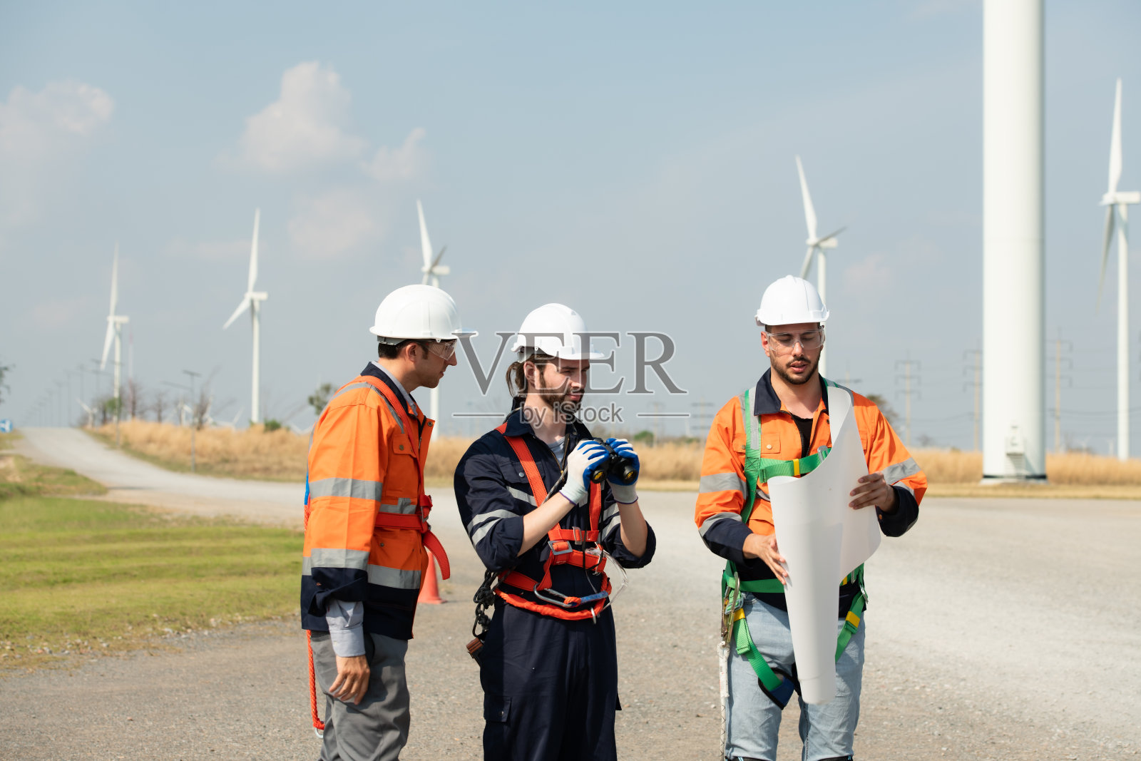 测量师和工程师检查巨大的风力涡轮机的效率,将风能转化为电能,然后用于日常生活。照片摄影图片