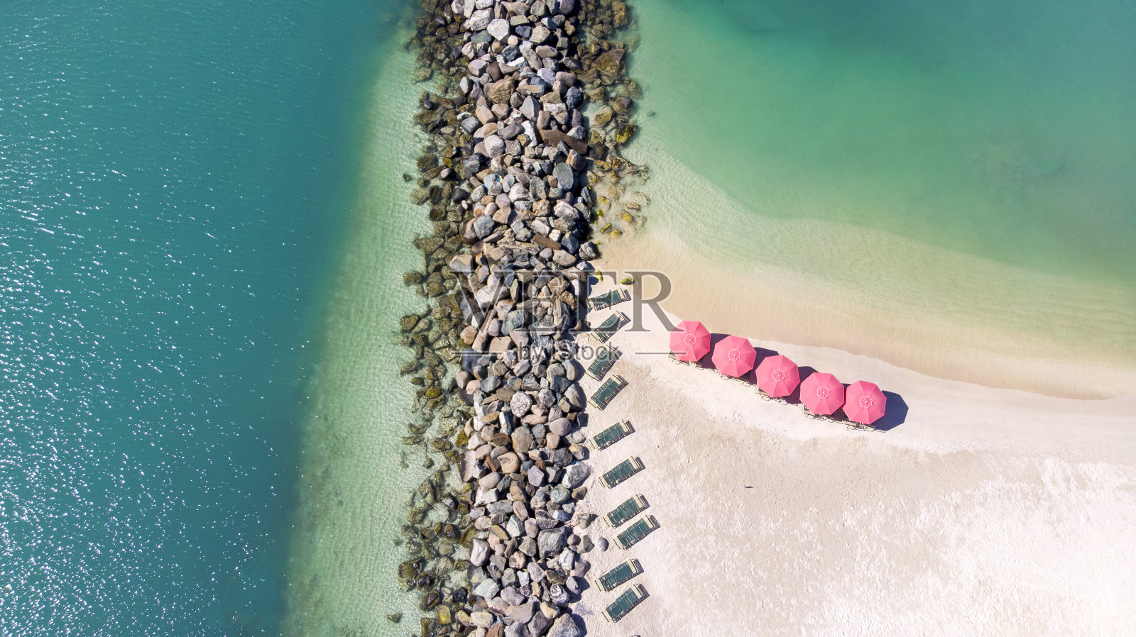 圣马丁沙滩上粉红色遮阳伞和苏床的鸟瞰图照片摄影图片