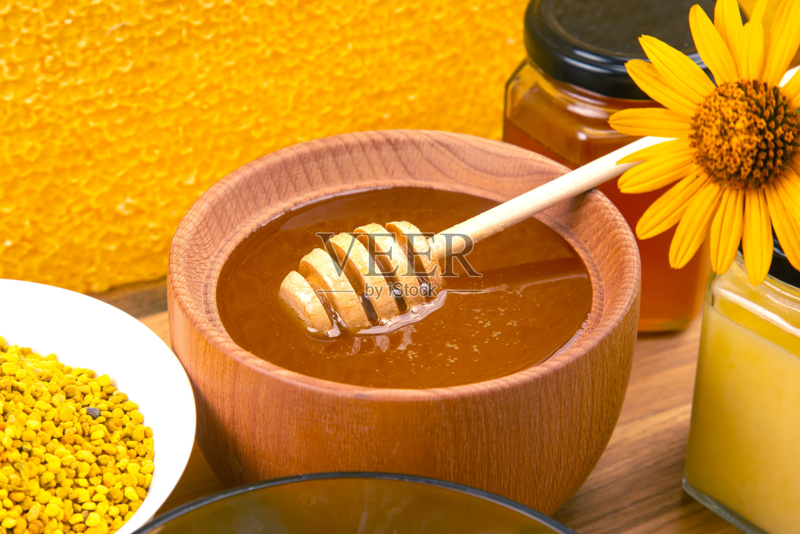 新鲜的花蜂蜜在木碗,勺子和蜂窝。健康生命的维生素食品照片摄影图片