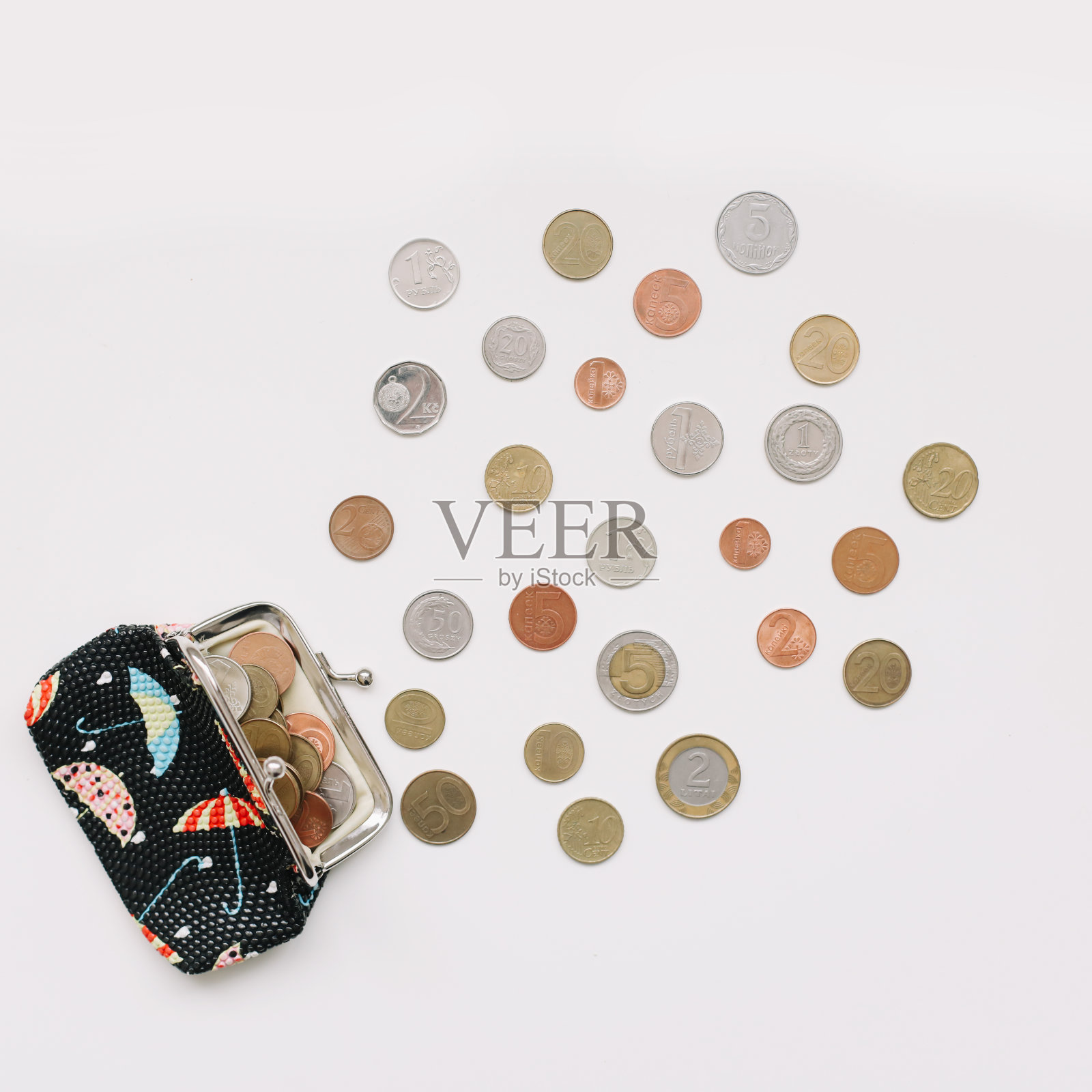 白色背景下,装满不同硬币的打开的钱包俯视图。金融危机、贫困、缺钱概念照片摄影图片