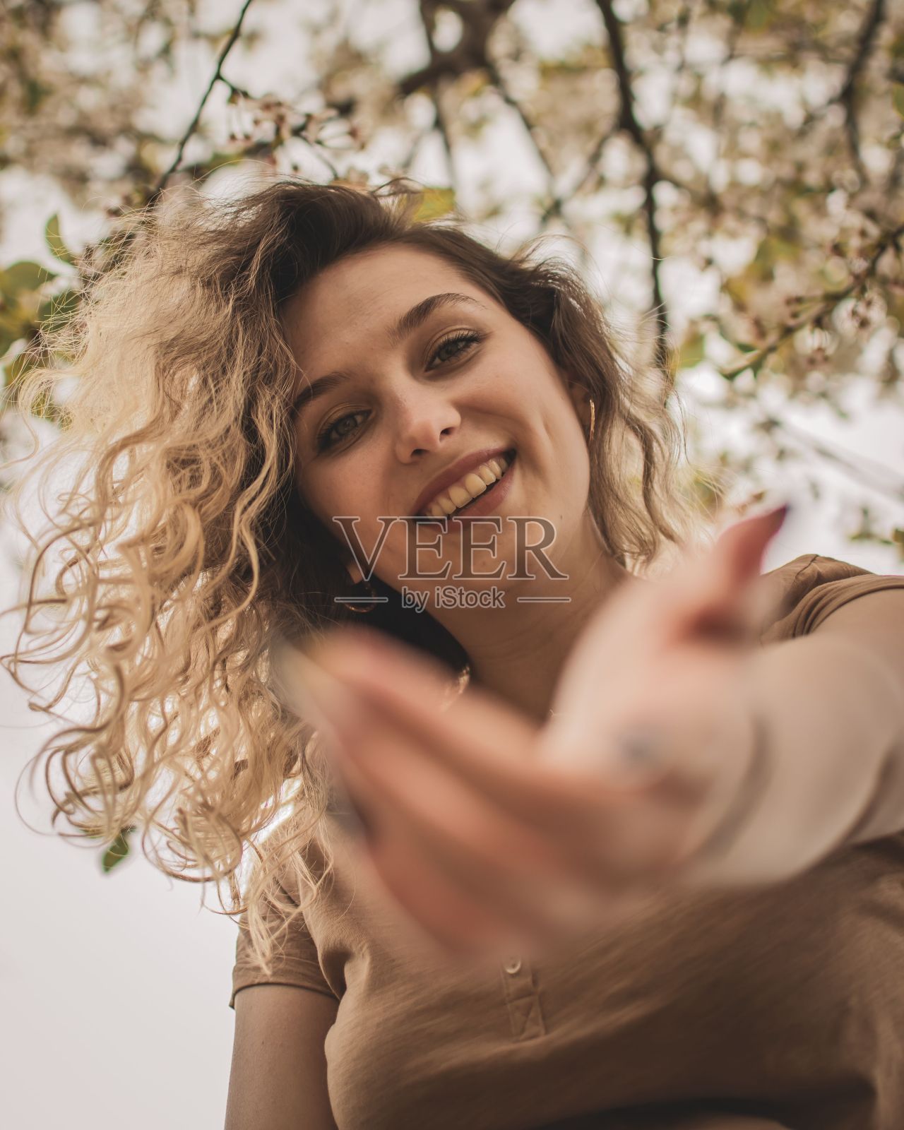 公园里穿着棕色t恤的年轻模特的肖像。照片摄影图片