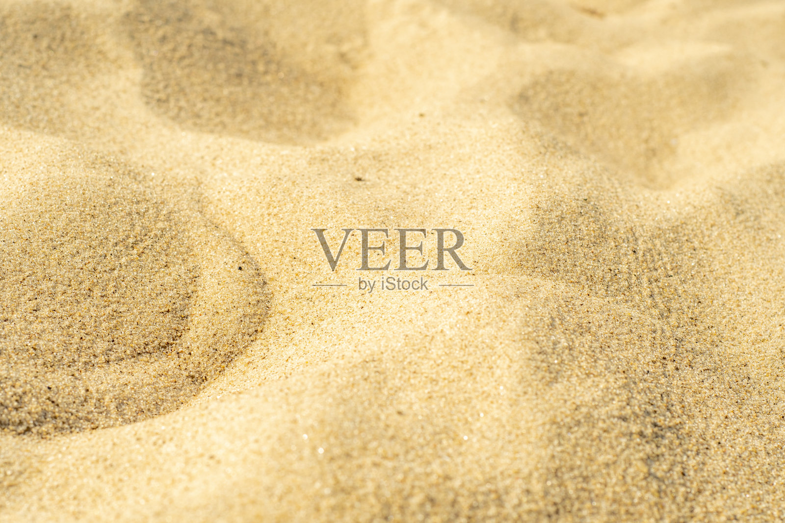 沙滩上的黄沙特写。干净沙滩上的小沙粒。色调照片与低景深。照片摄影图片